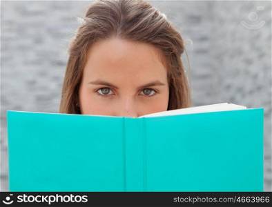 Portrait of woman close up with blue eyes reading a book&#xA;