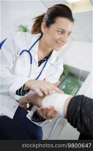 portrait of woman doctor bandaging hand