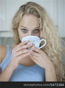 Portrait of woman drinking tea in kitchen