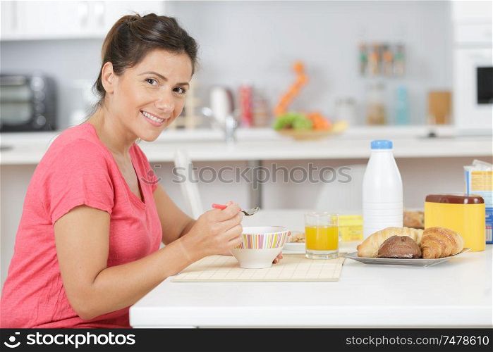 portrait of woman eating breakfast cereals at home