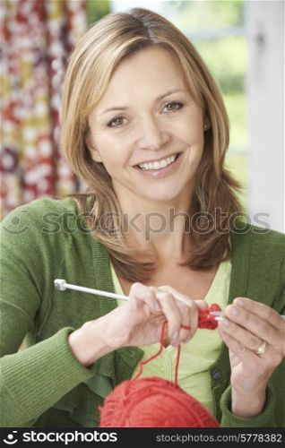 Portrait Of Woman Enjoying Knitting Garment At Home