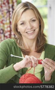 Portrait Of Woman Enjoying Knitting Garment At Home