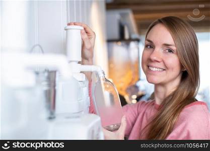 Portrait Of Woman Filling Container With Cleaning Product In Plastic Free Grocery Store