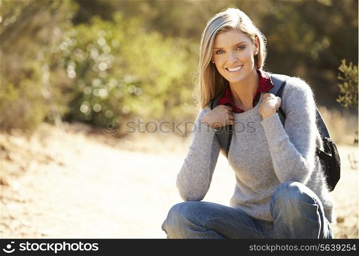 Portrait Of Woman Hiking In Countryside Wearing Backpack