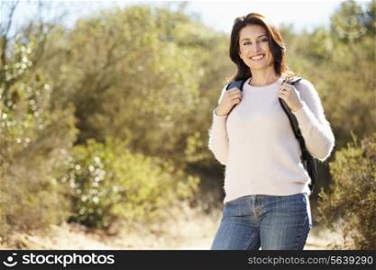 Portrait Of Woman Hiking In Countryside Wearing Backpack
