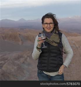 Portrait of woman holding a wine glass in desert, San Pedro de Atacama, El Loa Province, Antofagasta Region, Chile