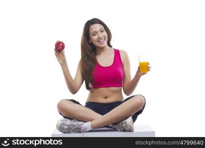 Portrait of woman holding apple and juice