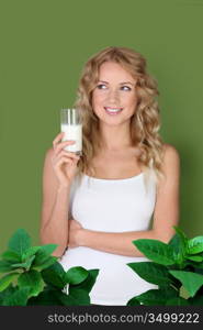 Portrait of woman holding glass of milk on green background