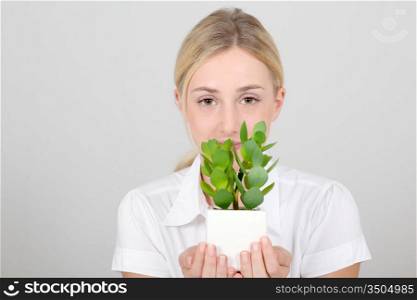 Portrait of woman holding green plant