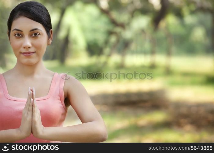 Portrait of woman holding hands in prayer position