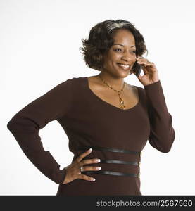 Portrait of woman holding telephone to ear and smiling.