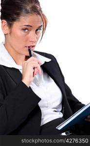 Portrait of woman in a suit with pen and notepad