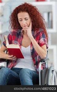 portrait of woman in a wheelchair holding a book