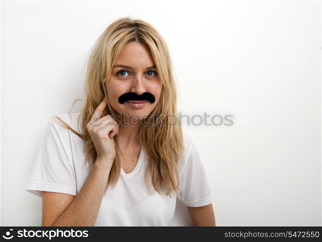 Portrait of woman in fake mustache against white background
