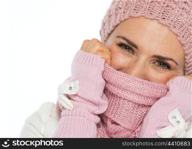 Portrait of woman in knit winter clothing closing face with scarf