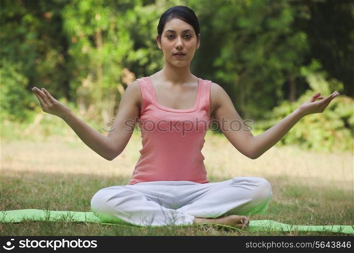 Portrait of woman in lawn sitting in lotus position