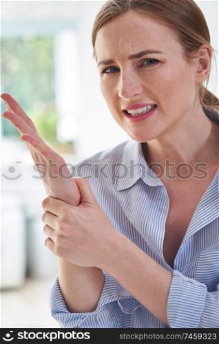 Portrait Of Woman In Pain Holding Wrist Suffering With Repetitive Strain Injury