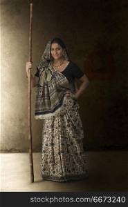 Portrait of woman in sari holding stick