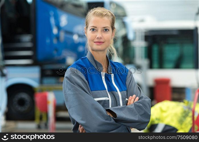 portrait of woman in workshop wearing overalls