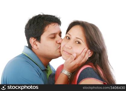 Portrait of woman looking at camera with man near by kissing her