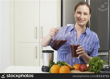 Portrait Of Woman Making Juice Or Smoothie In Kitchen