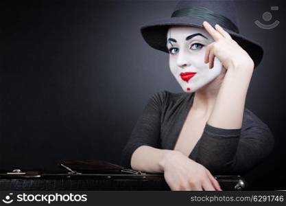 Portrait of woman mime with a suitcase on a black background