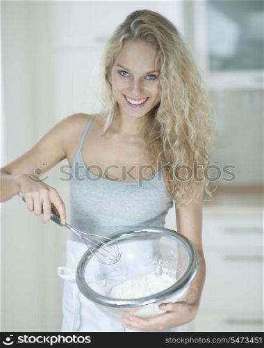 Portrait of woman mixing cookie batter in kitchen
