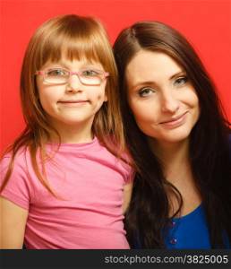 Portrait of woman mom and her child cute little girl daughter on red