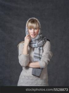 Portrait of woman on dark background wearing woolen accessories