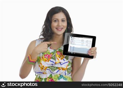 Portrait of woman pointing at digital tablet