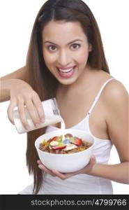 Portrait of woman pouring milk into a bowl of cereal