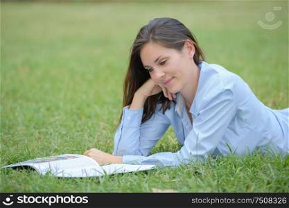 portrait of woman reading on the grass
