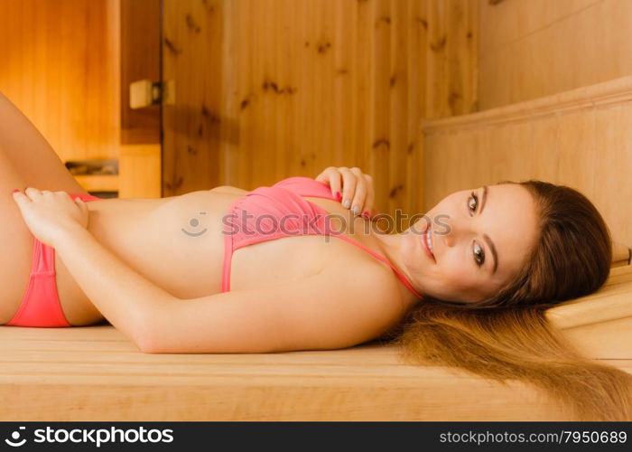 Portrait of woman relaxing in sauna. Spa wellbeing. Portrait of young woman relaxing in wooden finnish sauna. Attractive girl in bikini resting. Spa wellbeing pleasure.