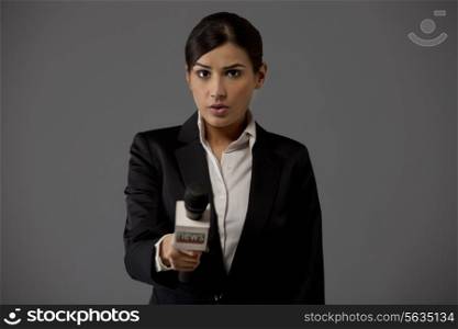 Portrait of woman reporter asking against colored background