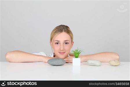 Portrait of woman set by pebbles and green plant