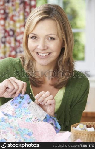 Portrait Of Woman Sewing Quilt At Home