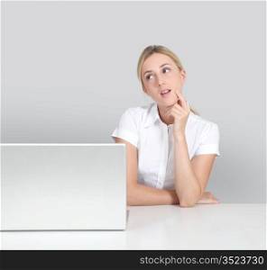 Portrait of woman sitting by laptop computer