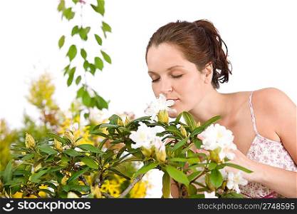 Portrait of woman smelling blossom of Rhododendron flower on white background