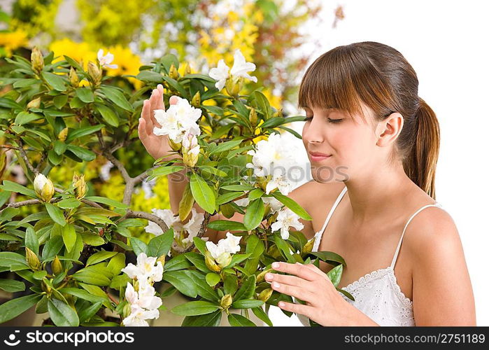 Portrait of woman smelling blossom of Rhododendron flower on white background