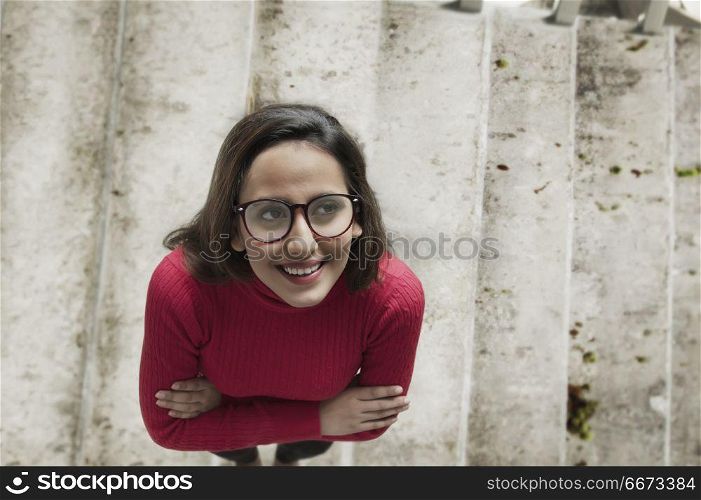 Portrait of woman standing on staircase looking up