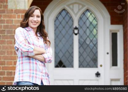 Portrait Of Woman Standing Outside Front Door Of Home