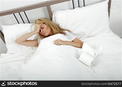 Portrait of woman suffering from cold and headache in bed
