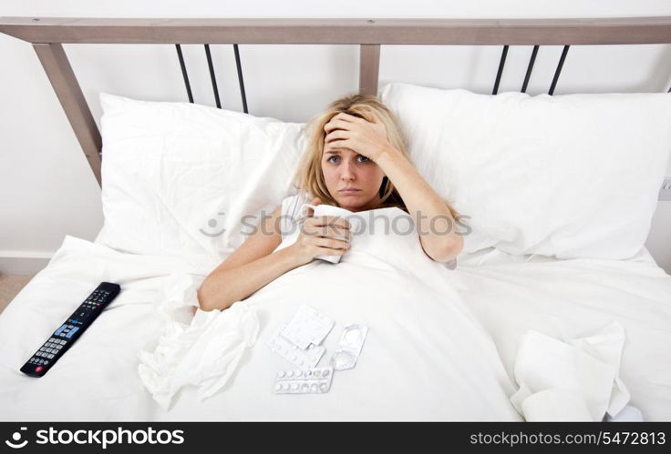 Portrait of woman suffering from cold having coffee in bed