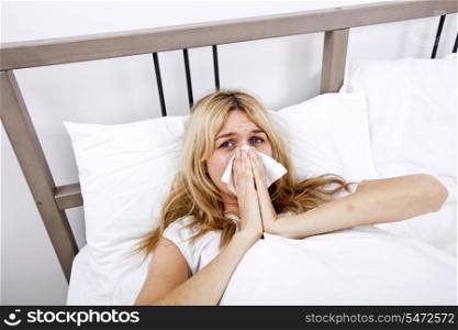 Portrait of woman suffering from cold in bed
