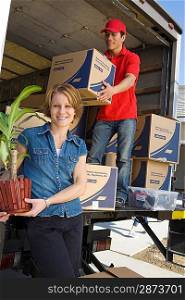 Portrait of woman unloading with worker truck of cardboard boxes