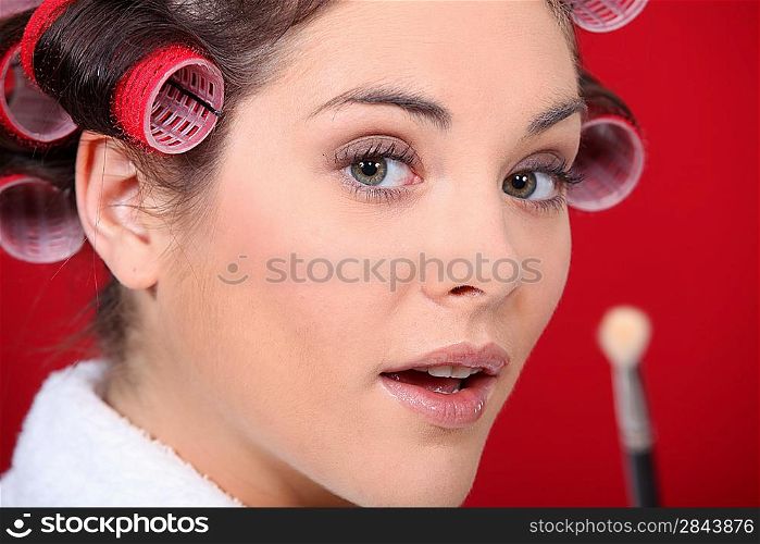 Portrait of woman with curlers and brush in hand