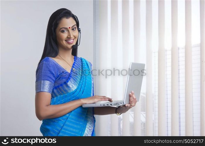 Portrait of woman with headset and laptop