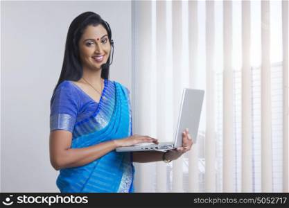 Portrait of woman with headset and laptop