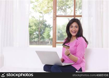 Portrait of woman with laptop and credit card