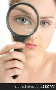 Portrait of woman with magnifier lens on eye isolated on white